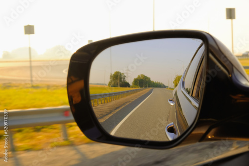 Look in the rear view mirror of a car. Car driving on the road.