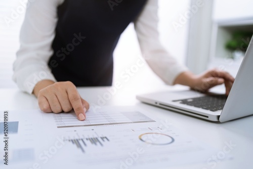 Businesswoman Accountant analyzing investment charts Invoice and pressing calculator buttons over documents. Accounting Bookkeeper Clerk Bank Advisor And Auditor Concept