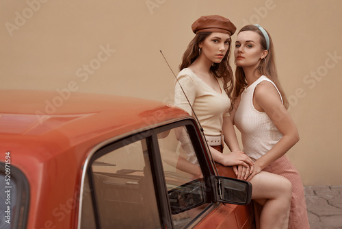 Obraz na płótnie Young beautiful models dressed in retro vintage style enjoying the old european city summertime lifestyle. Old fashioned clothes. w salonie