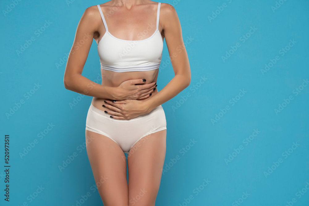 Torso of young unwell sick ill woman hold hand on stomach suffers pain pms isolated on yellow color background