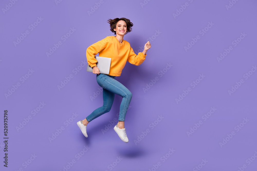 Full length body size view of attractive trendy motivated girl jumping running carrying netbook isolated on violet lilac color background