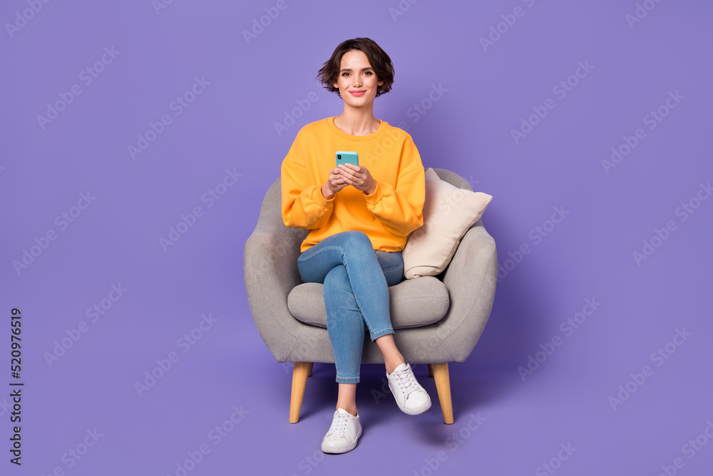 Portrait of attractive cheerful girl sitting using device chatting web site isolated over violet lilac color background Portrait of attractive cheerful girl sitting using device chatting web site isolated over violet lilac color background