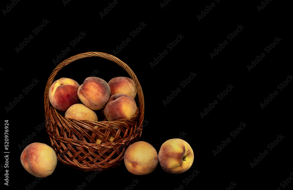 basket with a harvest of ripe peaches on a black background basket with a harvest of ripe peaches on a black background