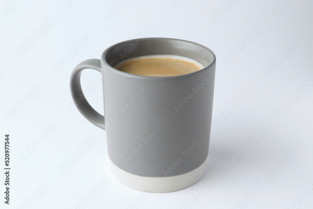 Grey mug of freshly brewed hot coffee on white background