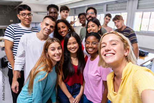 United multiracial big group of student friends taking selfie with teacher at college - Teenage high school people having fun together in classroom - Youth lifestyle, education and community concept photo