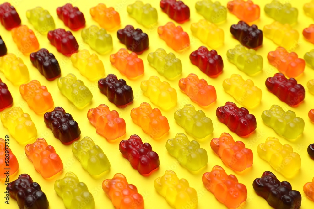 Delicious gummy bear candies on yellow background Delicious gummy bear candies on yellow background