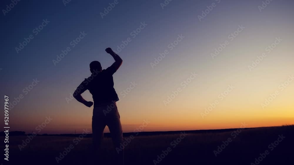 Winner concept: Silhouette of champion man on golden sunset background
