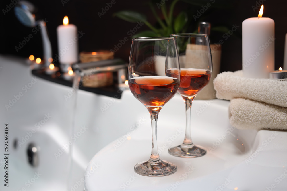 Bathtub with glasses of wine and candles indoors. Romantic atmosphere Bathtub with glasses of wine and candles indoors. Romantic atmosphere