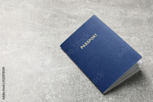 Blank blue passport on grey table , space for text