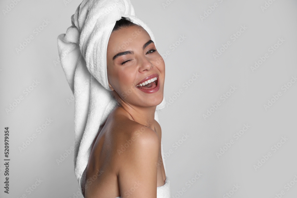 Beautiful young woman with towels on light background Beautiful young woman with towels on light background