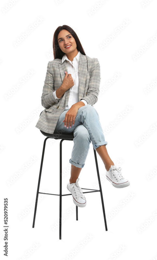 Beautiful young woman sitting on stool against white background Beautiful young woman sitting on stool against white background