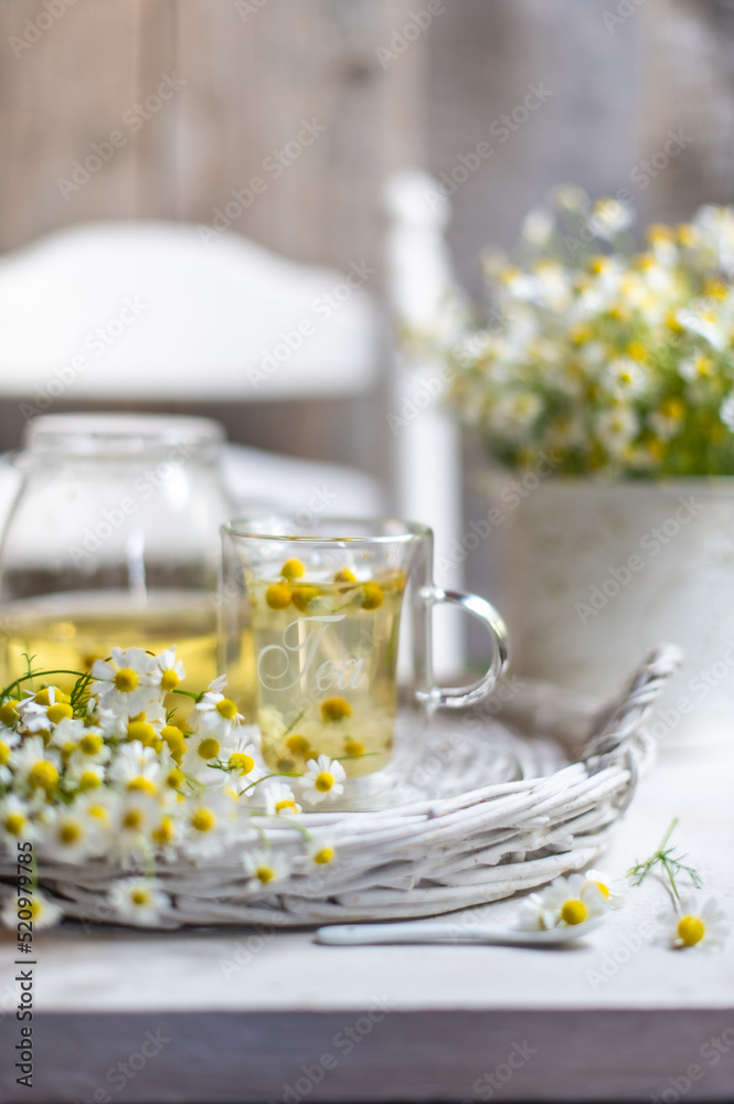 cup of chamomile tea with chamomile flowers
