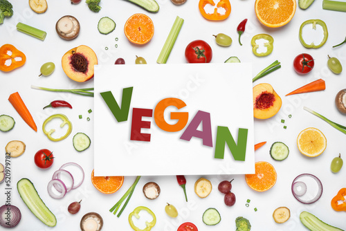 Paper card with word Vegan  fresh vegetables and fruits on white background  flat lay