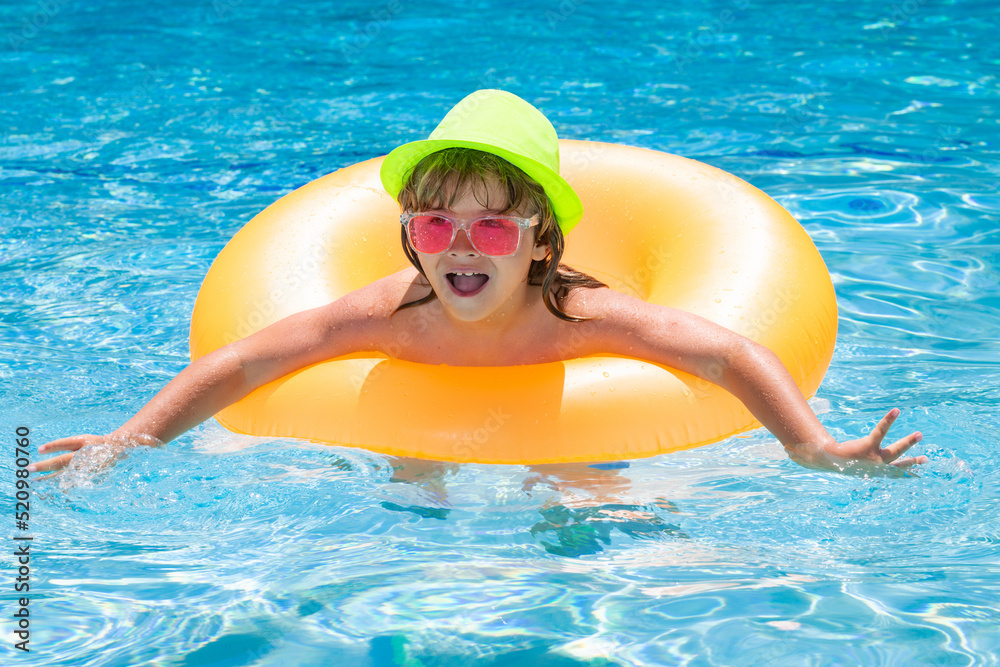 Child splashing in swimming pool. Active healthy lifestyle, swim water sport activity on summer vacation with child. Child in water play with inflatable toy ring.