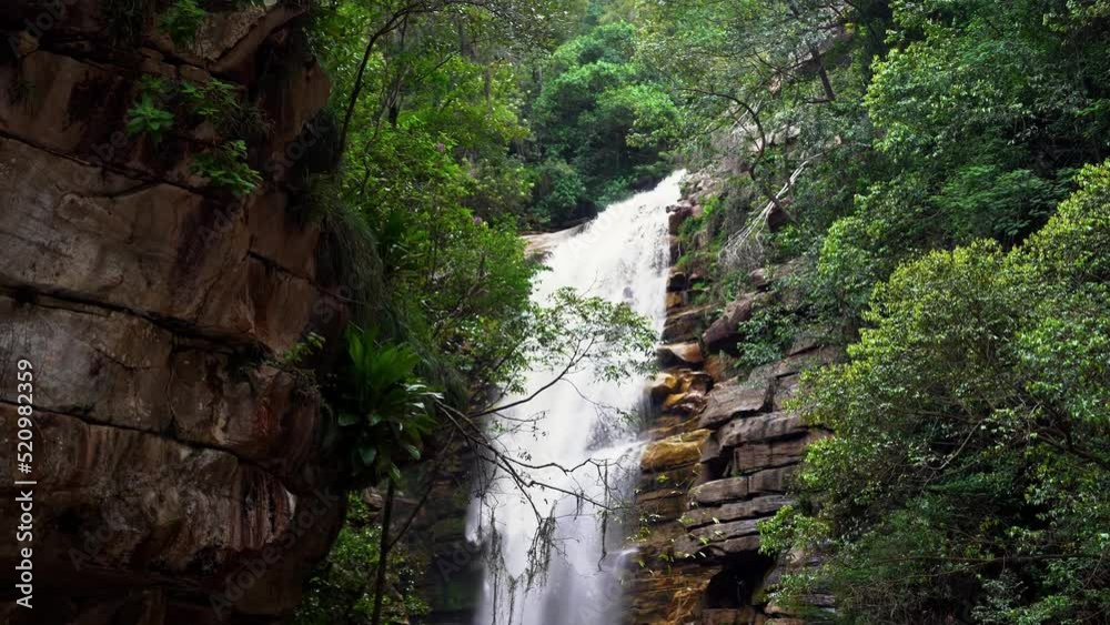 Stunning 4K handheld shot of the beautiful Mosquito waterfall from behind foliage and a cliff in the Chapada Diamantina National Park in the Northeastern State of Brazil Bahia. Stunning 4K handheld shot of the beautiful Mosquito waterfall from behind foliage and a cliff in the Chapada Diamantina National Park in the Northeastern State of Brazil Bahia.