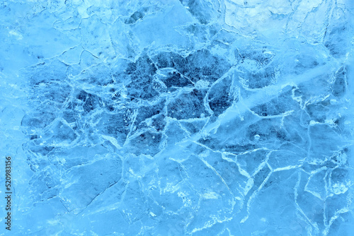 Blue cracked ice. Frozen water, sea. Frosty winter ice texture with natural cracks. Macro photography.