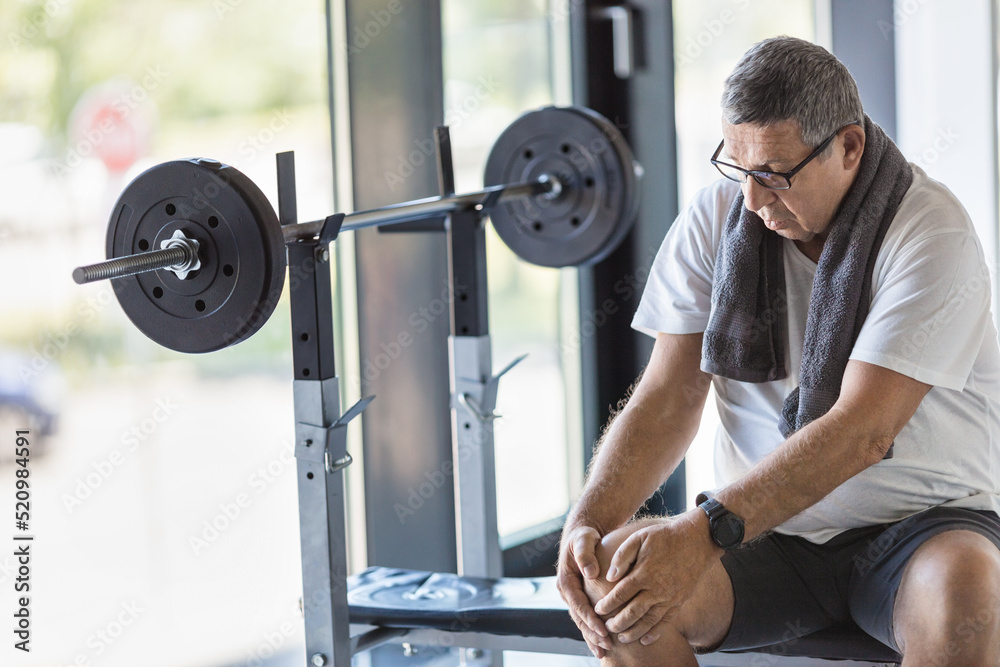 Active senior in gym with knee injury Active senior in gym with knee injury