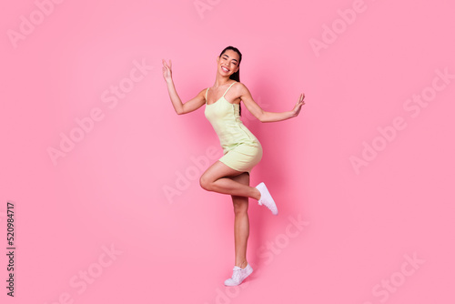 Full length photo of charming pretty girl dressed yellow sarafan dancing smiling isolated pink color background