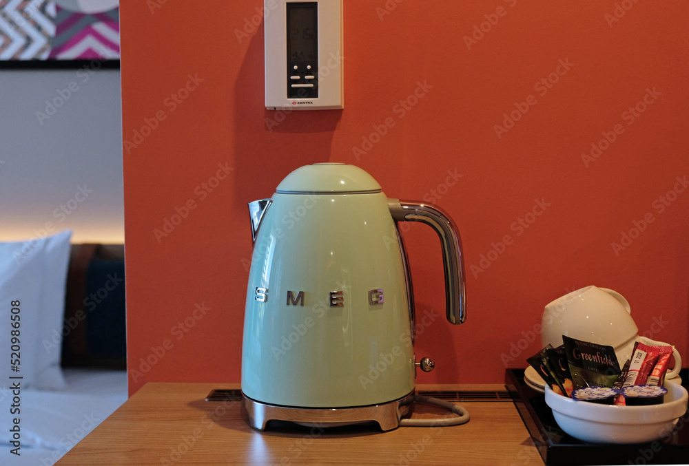 Green electric kettle SMEG for boiling water and making tea or coffee on  table in hotel as design element. Household kitchen appliances for makes  hot drinks. Moscow - July, 2022. Stock Photo