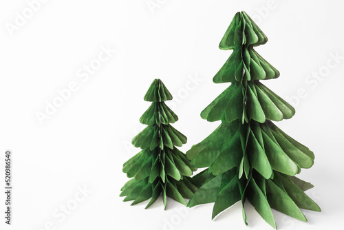 Handmade foldable Christmas trees from plastic free material - green paper isolated on white background. DIY concept.