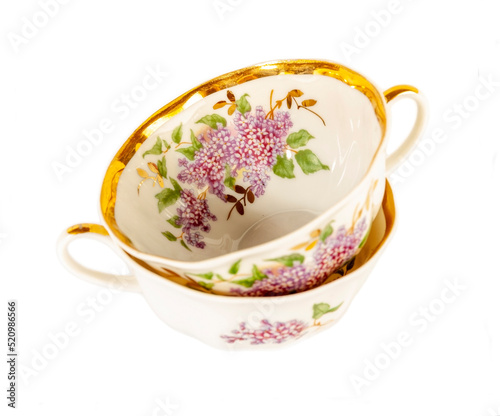 Porcelain teacups with flowers isolated on white background
