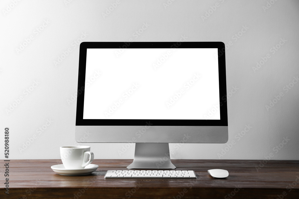 Fototapeta premium Workplace with modern computer monitor, keyboard and mouse on wooden table. Mockup for design