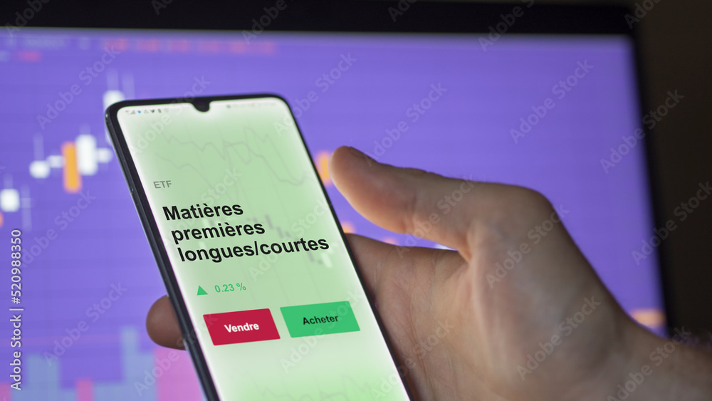 Un investisseur analyse un fonds etf matières premières longues/courtes sur un graphique. Un téléphone affiche le cours de l'ETF. Texte en français francais Matières premières longues/courtes Un investisseur analyse un fonds etf matières premières longues/courtes sur un graphique. Un téléphone affiche le cours de l'ETF. Texte en français francais Matières premières longues/courtes
