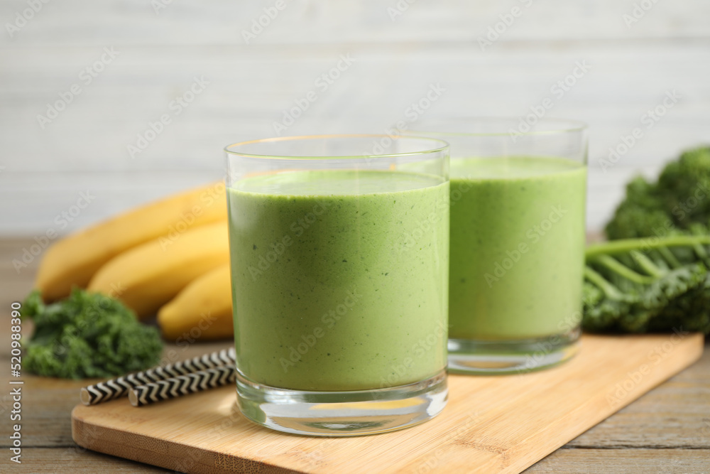 Tasty fresh kale smoothie on wooden table, closeup