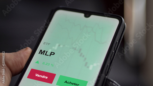 Un investisseur analyse un fonds etf mlp sur un graphique. Un téléphone affiche le cours de l'ETF. Texte en français francais MLP