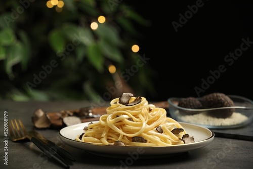 Tasty fettuccine with truffle on grey table