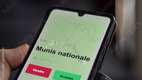 Un investisseur analyse un fonds etf munis nationale sur un graphique. Un téléphone affiche le cours de l'ETF. Texte en français francais Munis nationale