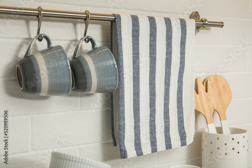 Cuadro en lienzo Kitchen towel and cups hanging on rack indoors