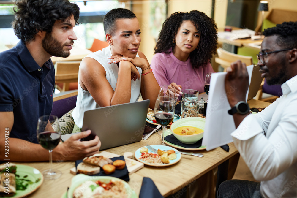An African employer has a business meeting with workers in a restaurant. An African employer has a business meeting with workers in a restaurant.