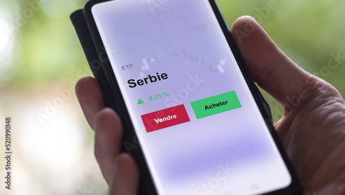 Un investisseur analyse un fonds etf serbie sur un graphique. Un téléphone affiche le cours de l'ETF. Texte en français francais Serbie photo