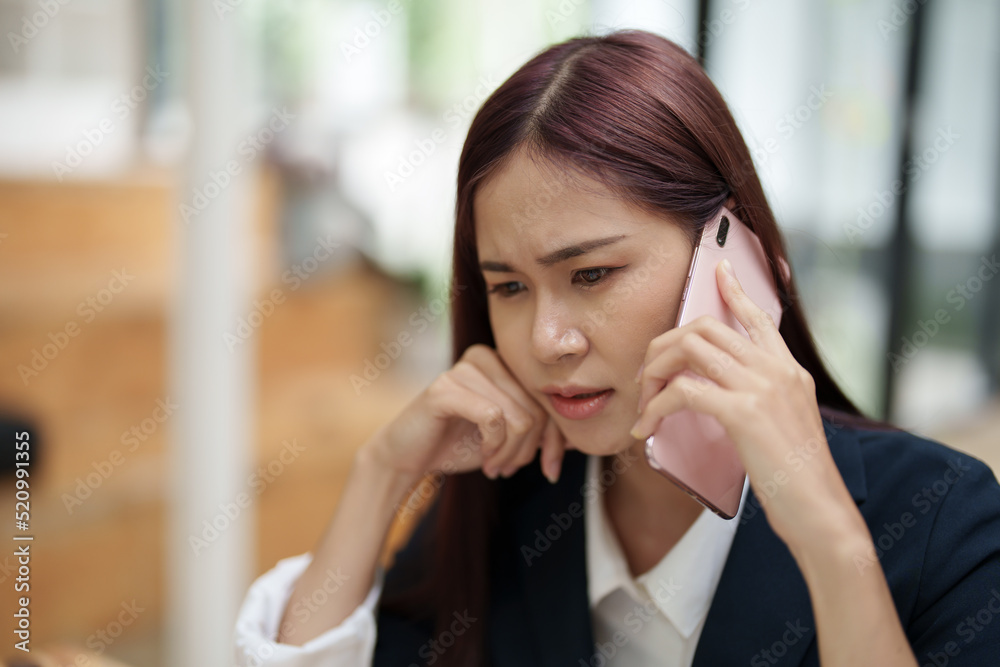 businesswoman showing a serious expression while talking on the phone