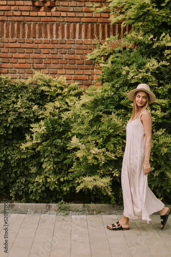 Young woman with hat walkin...