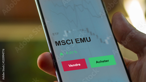 Un investisseur analyse un fonds etf msci emu sur un graphique. Un téléphone affiche le cours de l'ETF. Texte en français francais MSCI EMU