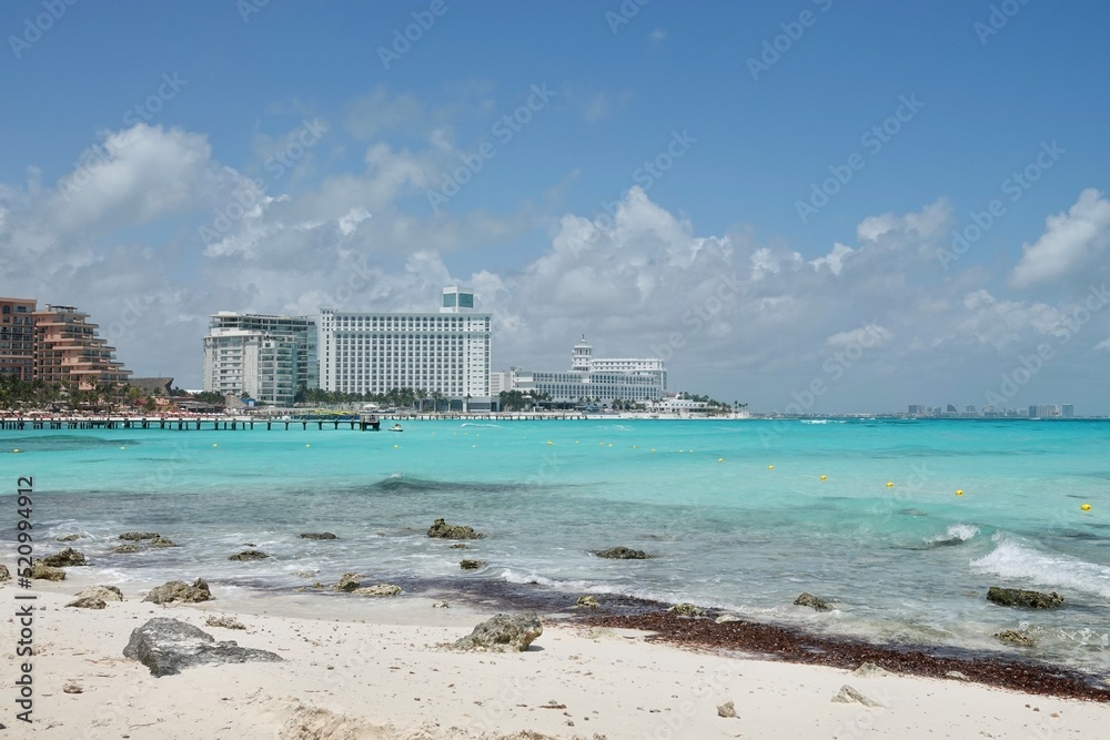 Fototapeta premium Caribbean beach with turquoise sea water and beautiful view on Hotel Zone at Cancun, Quintana Roo, Mexico. Paradise, Vacations and tourism concept. High quality photo