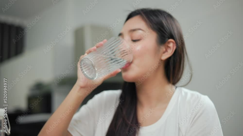 Young female drinking water in glass for refreshing for diet and wellness on table. Beautiful woman happily drink fresh water before breakfast in kitchen in the morning. Healthy food concept. Young female drinking water in glass for refreshing for diet and wellness on table. Beautiful woman happily drink fresh water before breakfast in kitchen in the morning. Healthy food concept.