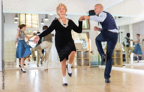 Mature woman dancing swing with young man