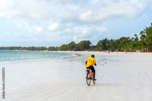bycycle ridden on an open beach in a tropical setting
