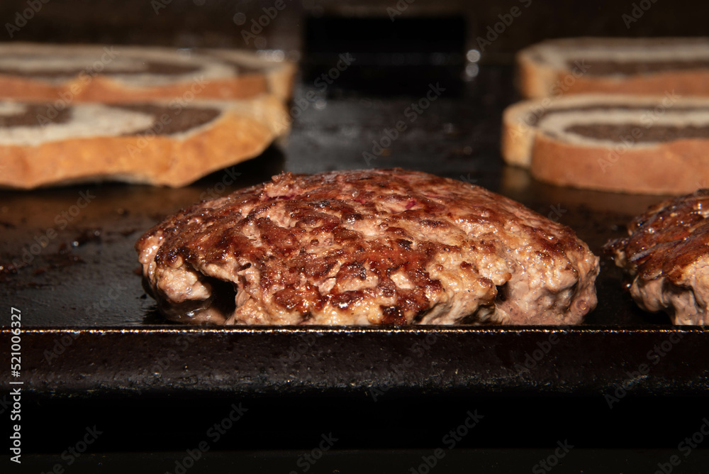 Griddle cooking.  Hamburger paddies cooking on the griddle.