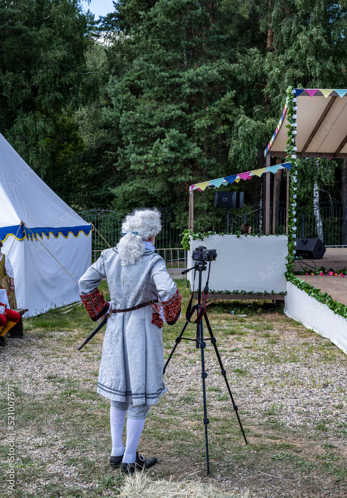 a man dressed as a rich 18th century nobleman takes pictures with a modern camera a man dressed as a rich 18th century nobleman takes pictures with a modern camera