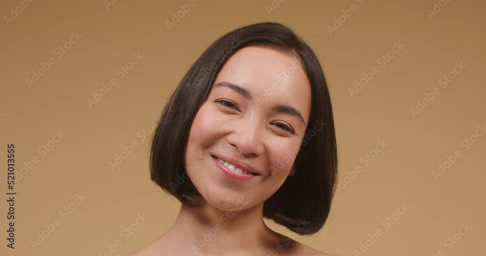 Young Asian woman with bare shoulders poses smiling laughs Young Asian woman with bare shoulders poses smiling laughs