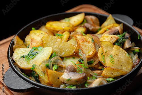 Homemade fried potatoes with mushrooms and onions in a frying pan. selective focus