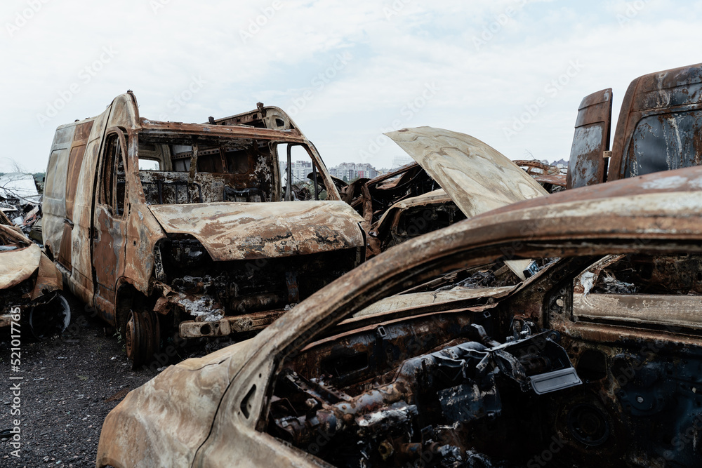 Burned civilian car. Stacked vehicles. War in Ukraine.