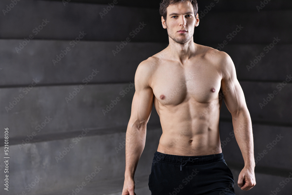Portrait of strong man on dark background. Sport workout