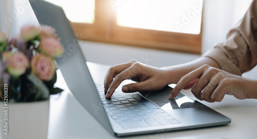 Businesswoman using laptop computer keyboard at the office.