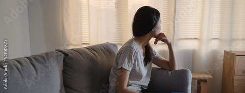 Foto Asian woman covering her face feeling sorrow and depressed sit in the dark bedro