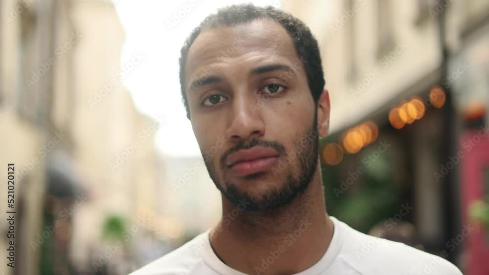 Serious portrait of attractive young African american man standing in the city street and looking at the camera. Handsome guy outside. Serious portrait of attractive young African american man standing in the city street and looking at the camera. Handsome guy outside.
